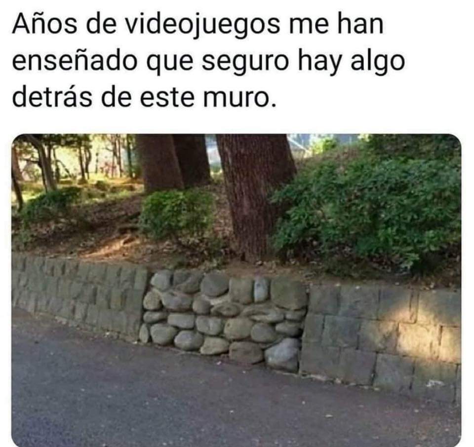 Muro de piedra junto a una carretera con un tramo hecho de piedras redondas diferentes.