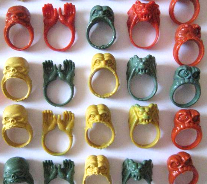 Anillos de plástico de colores con calaveras, manos y monstruos.