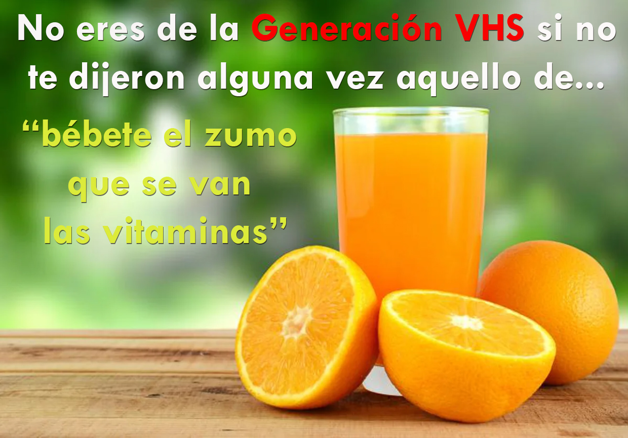 Vaso de zumo de naranja junto a naranjas partidas por la mitad sobre una mesa de madera.