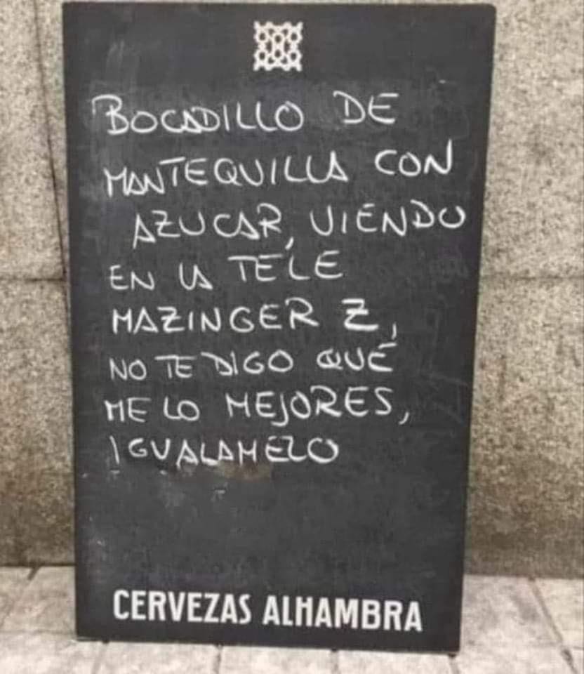 Pizarra negra de Cervezas Alhambra con un texto escrito a tiza sobre el bocadillo de mantequilla con azúcar y Mazinger Z.