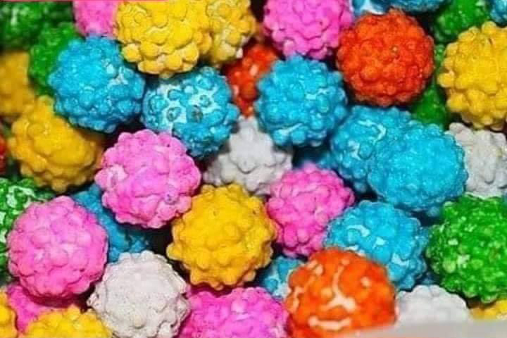 Montón de bolitas de anís de colores rosa, azul, amarillo y blanco.