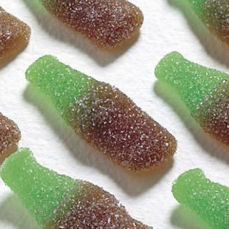 Gominolas con forma de botella de cola, mitad verde y mitad marrón, cubiertas de azúcar.