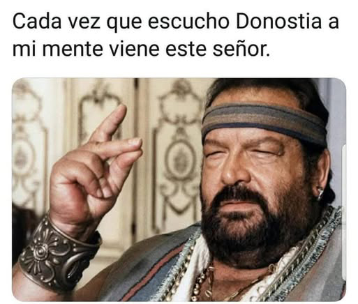 Bud Spencer con barba, cinta en el pelo y pulsera de metal haciendo un gesto con la mano.