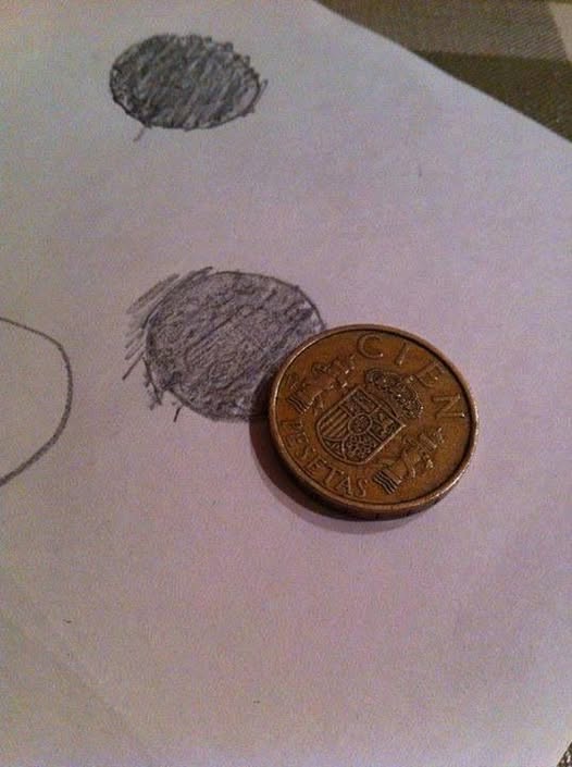 Papel con monedas calcadas a lápiz junto a una moneda de peseta.