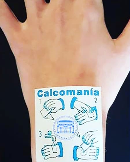 Mano con una calcomanía con las instrucciones para ponerla.