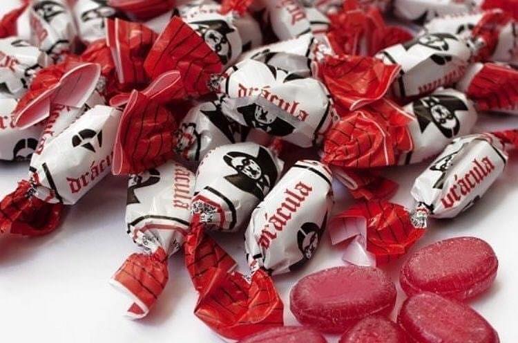 Montón de caramelos Drácula con envoltorio rojo y blanco.