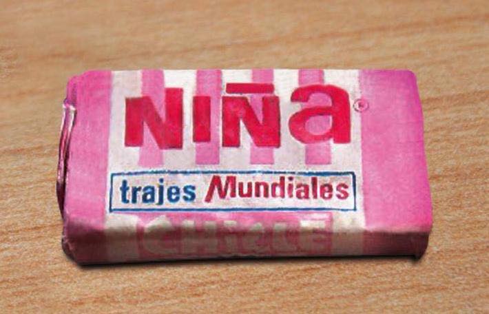 Chicle Niña en envoltorio rosa con el texto trajes mundiales.