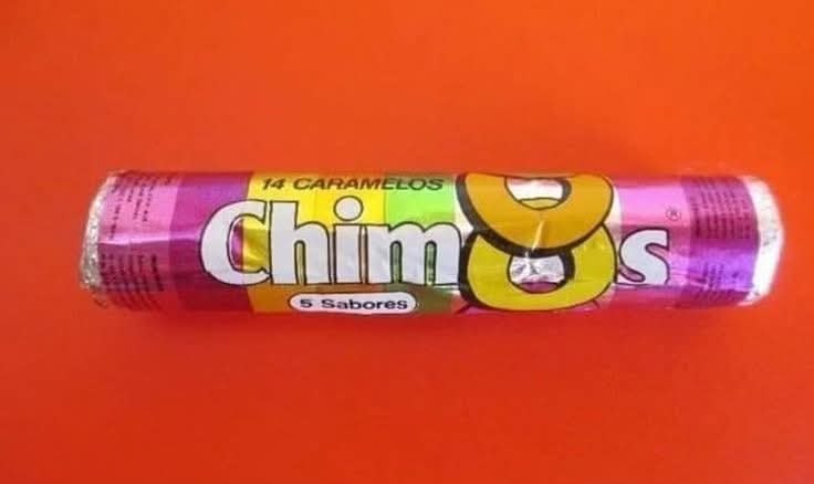 Tubo de caramelos Chimos de cinco sabores sobre fondo naranja.