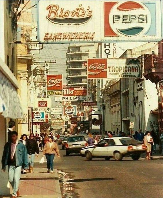 Calle con carteles de Pepsi y Coca-Cola.