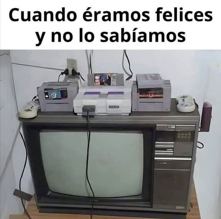Consola Super Nintendo con dos mandos y cartuchos encima de un televisor de tubo antiguo.