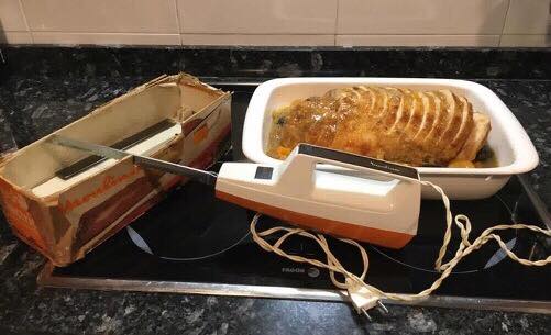 Cuchillo eléctrico Moulinex junto a un asado.