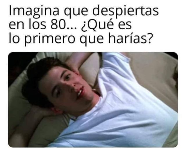 Chico con camiseta blanca tumbado en la cama con las manos detrás de la cabeza.