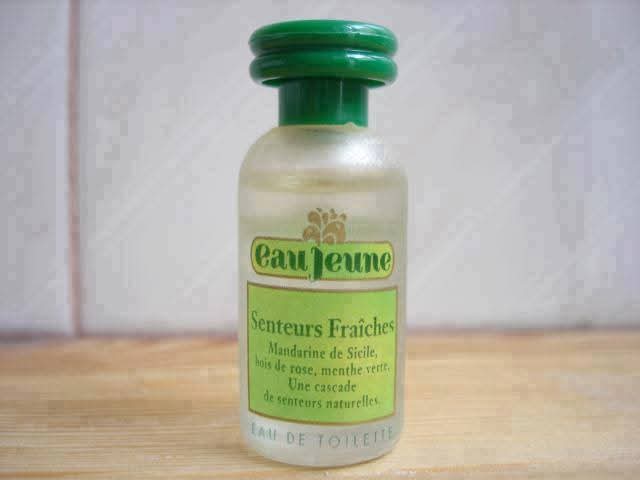 Frasco de colonia Eau Jeune con tapón verde.