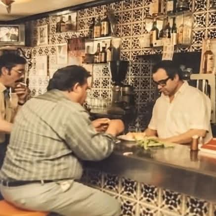 Hombres almorzando en la barra de un bar antiguo