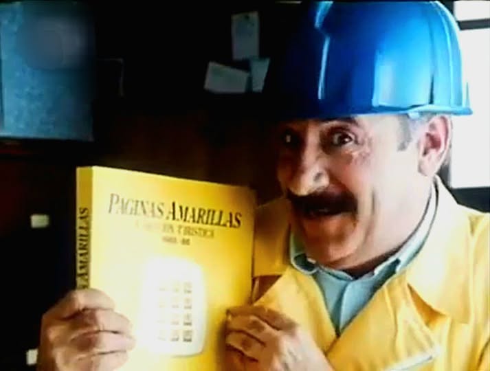 Hombre con casco azul sujetando un ejemplar de las Páginas Amarillas