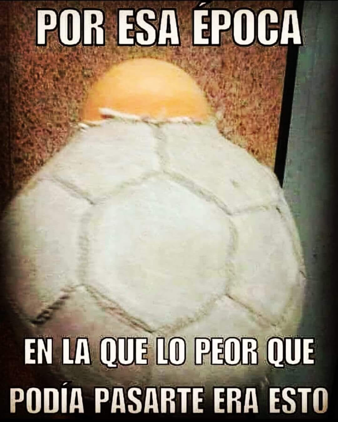 Balón de fútbol blanco muy gastado con la cámara naranja saliendo por una costura rota.