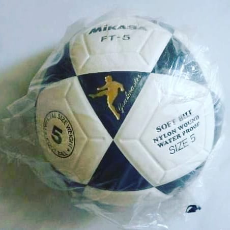 Balón de fútbol Mikasa blanco y azul marino dentro de una bolsa de plástico.