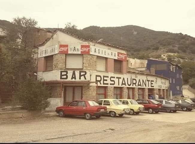 Edificio de bar restaurante de carretera con coches aparcados delante