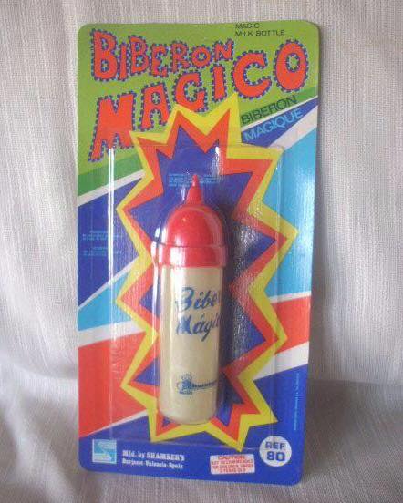 Biberón de juguete con tapa roja en su blíster original de colores con el rótulo Biberón Mágico.
