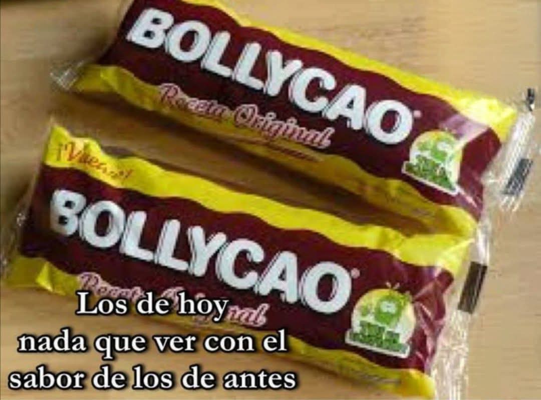 Dos bollos Bollycao envueltos en su paquete granate y amarillo sobre una mesa de madera.