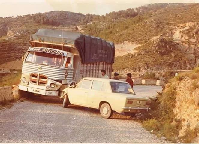 Camión cargado y un coche en una carretera de montaña