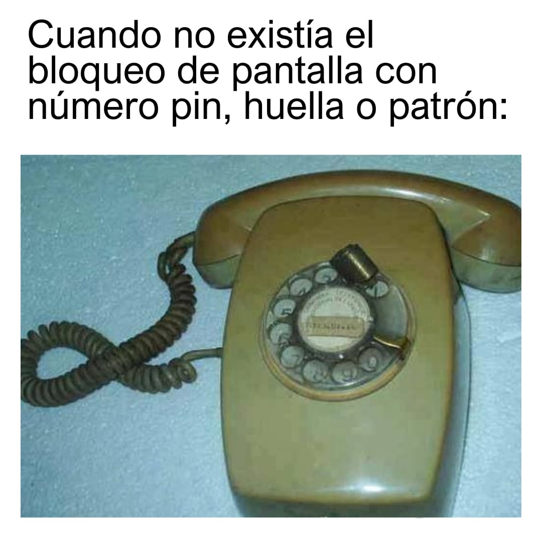 Teléfono de disco antiguo de color verde con un pequeño candado metido en los agujeros del disco.