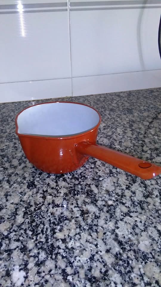 Cazo esmaltado naranja sobre una encimera