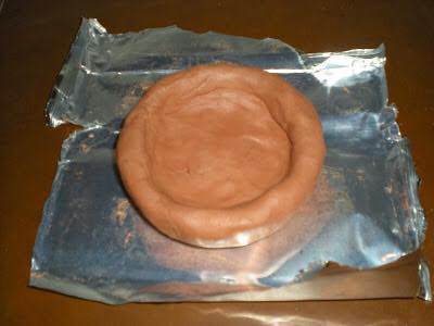 Cenicero de arcilla sobre papel de aluminio