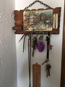 Colgador de llaves de madera con una postal de ciudad y un termómetro