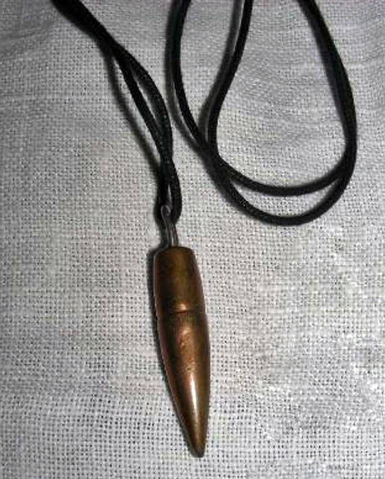 Colgante metálico con forma de bala en un cordón negro.