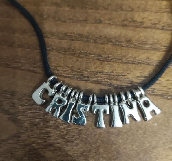 Collar con letras plateadas que forman el nombre Cristina.