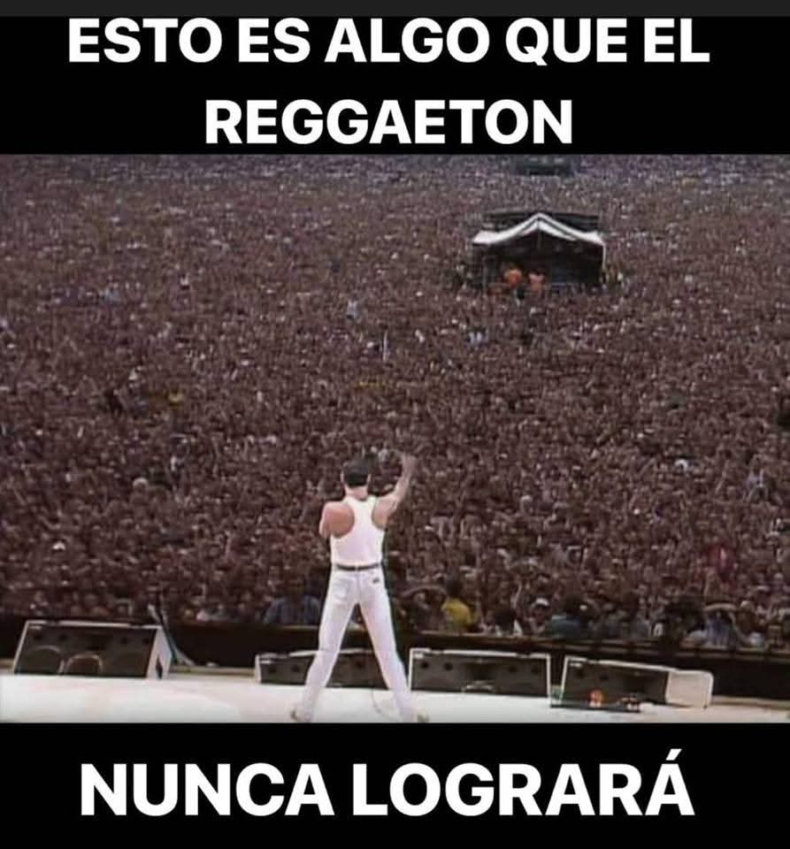 Cantante con camiseta blanca de tirantes, de espaldas en el escenario, ante un estadio lleno de gente.