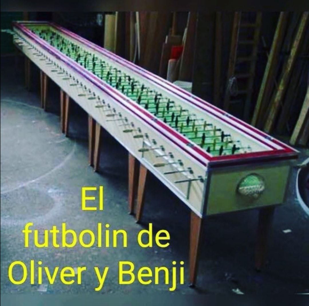 Futbolín de madera larguísimo con muchas barras de jugadores, en un taller.