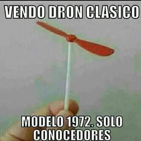 Mano sujetando una hélice de juguete de plástico rojo montada en un palito.