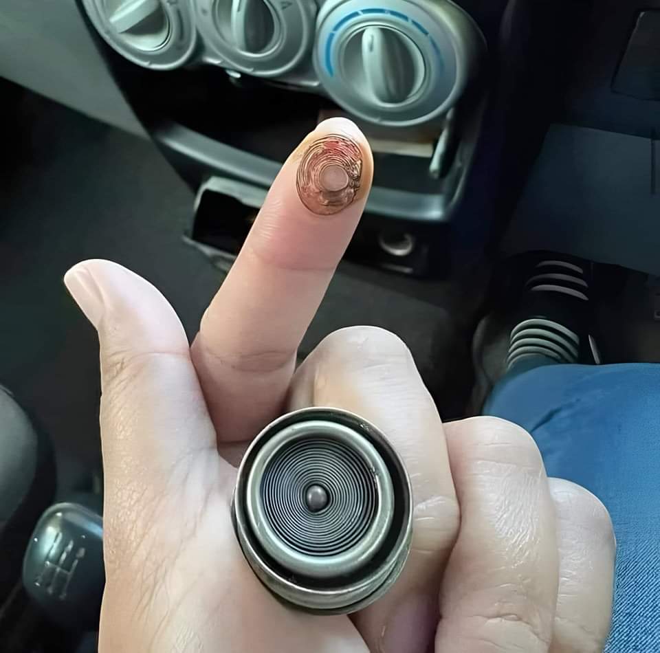 Dedo con la marca en espiral de un mechero de coche.