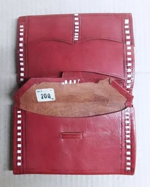 Monedero de piel roja con costuras blancas abierto