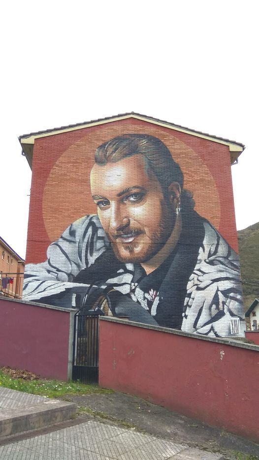 Mural con el retrato de un hombre pintado en la fachada de una casa