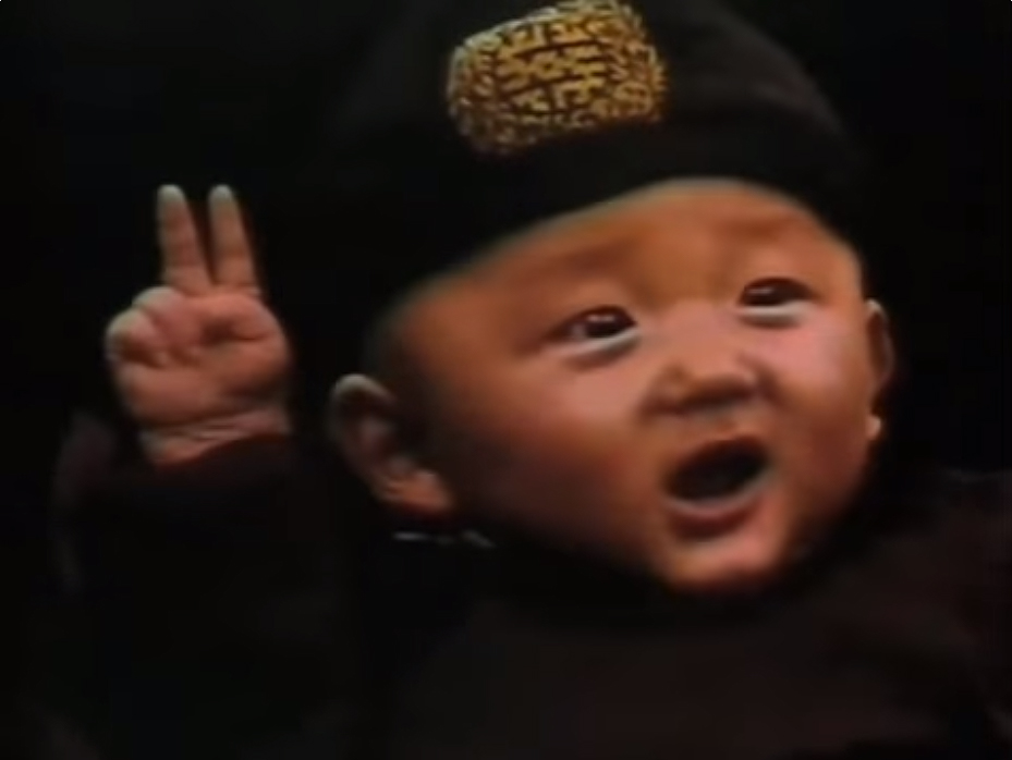 Niño oriental con gorro haciendo el signo de la victoria