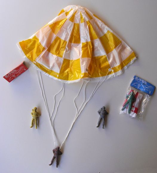 Paracaídas de plástico amarillo y blanco con soldaditos.