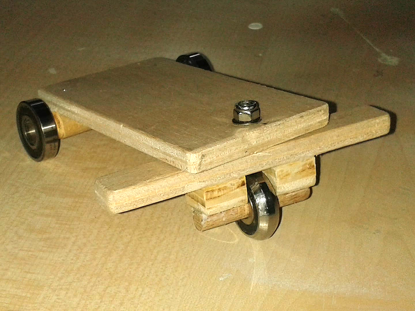 Patinete hecho con tablas de madera y rodamientos.