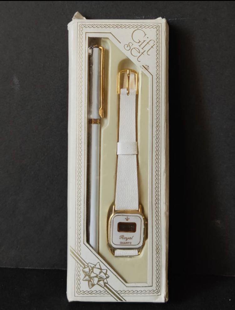 Estuche de regalo con un bolígrafo y un reloj digital de correa blanca.