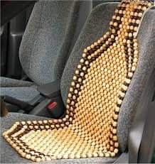 Cubreasientos de bolitas de madera colocado sobre el asiento de un coche.