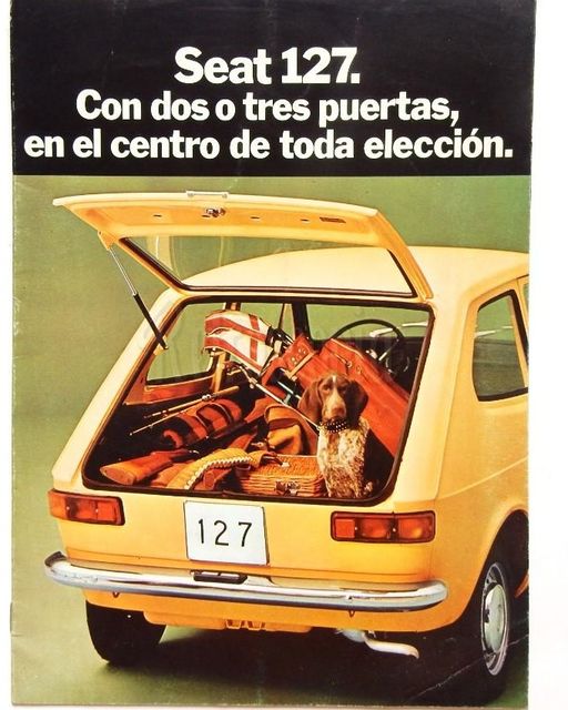 Catálogo antiguo del Seat 127 amarillo con el maletero abierto lleno de equipaje y un perro sentado.