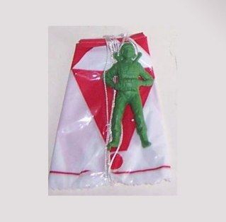 Soldado de plástico verde con paracaídas en su bolsa.