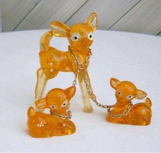 Figuritas de cervatillos de resina ámbar unidas por una cadena.