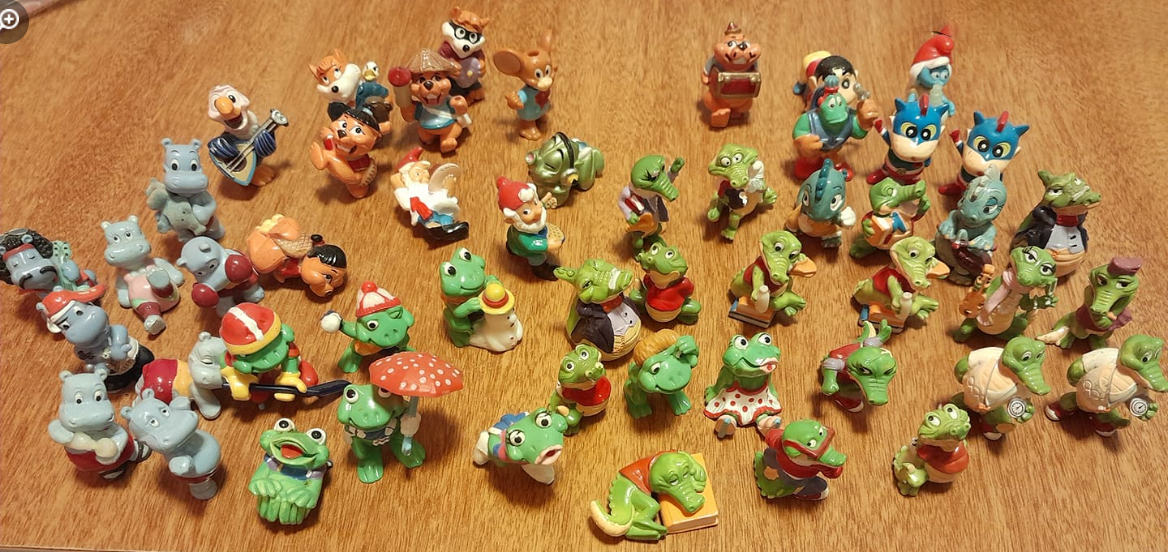 Decenas de figuritas de los huevos Kinder sobre una mesa.