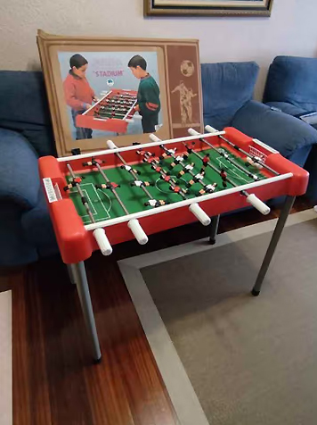 Futbolín de juguete rojo con su caja.