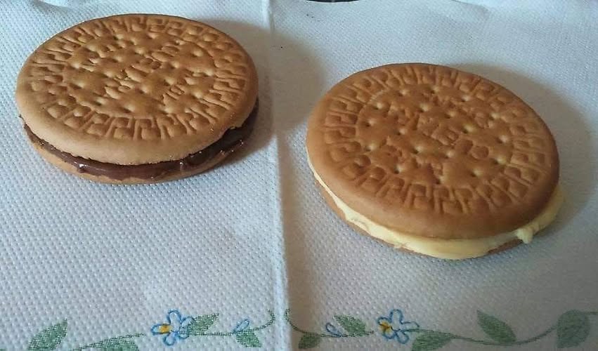 Dos sándwiches de galleta María, uno con chocolate y otro con mantequilla.