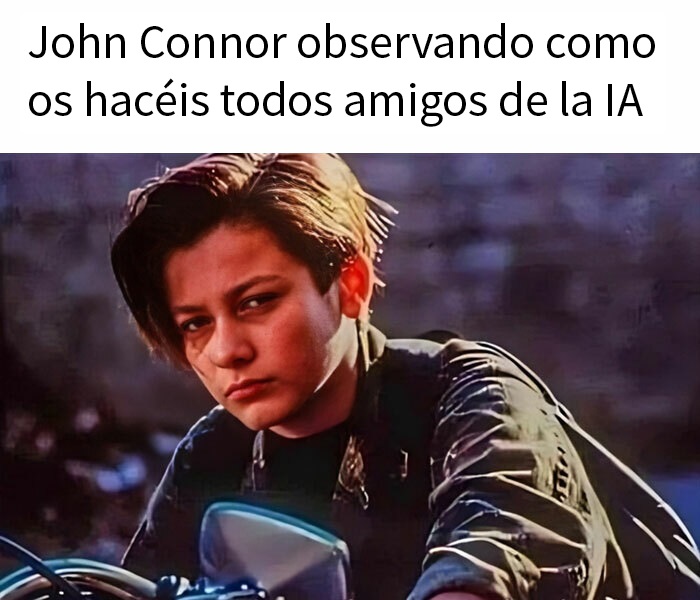 Fotograma de un chico con melena castaña y chaqueta de cuero, subido a una moto y con cara seria.