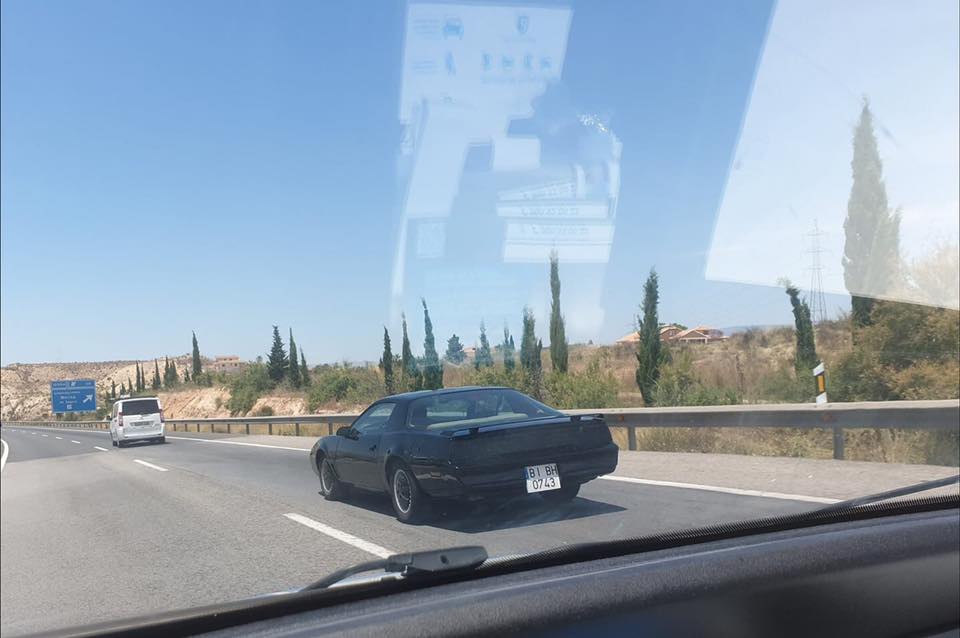 Coche negro como KITT en una autovía.